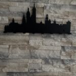 Decorative metal wall art skyline design on stone wall in London